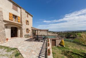 an external view of a stone house with a patio at El Cup in San Martín de Tous