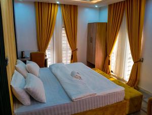 a bedroom with a large bed with pillows at Joebrown Palace Hotel & Suite in Akitan