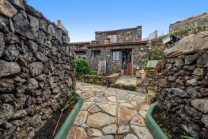a stone house with a stone wall at Tesbabo Rural - Mimo in Mocanal