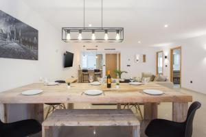 a dining room and living room with a large wooden table at Lujoso cerca de playa in Jávea