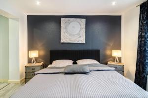 a bedroom with a large bed with two lamps at Femeer 01 in Wilhelmshaven