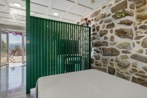 a green screen in a room with a stone wall at Quinta Santa Marinha in Arcos de Valdevez +65 photos