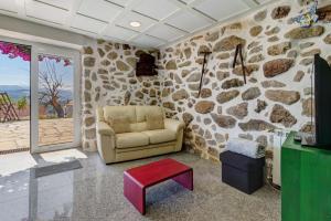 a living room with a chair and a stone wall at Quinta Santa Marinha in Arcos de Valdevez