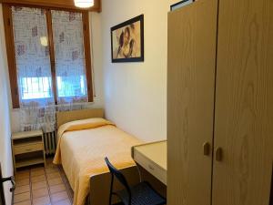 a small bedroom with a bed and a desk at Luna Apartment in Rimini