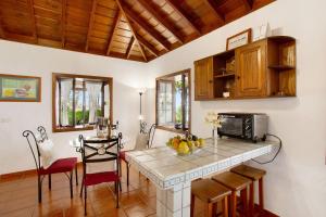 a kitchen and dining room with a table and a microwave at Casa Rural Arecida in Tijarafe +14 photos