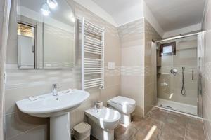 a white bathroom with a sink and a toilet at La Castellana in Monte SantʼAngelo