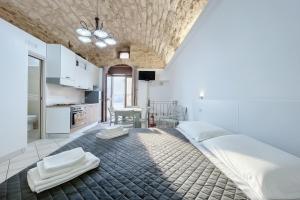 a bedroom with a large bed and a kitchen at La Castellana in Monte SantʼAngelo