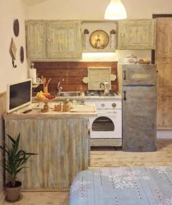 an old kitchen with a stove and a refrigerator at The Cottage by the lake 1 in San Maurizio dʼOpaglio