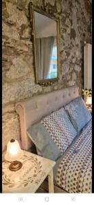a mirror on a wall with a bed and a table at The Cottage by the lake 1 in San Maurizio dʼOpaglio