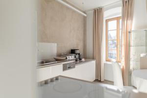 a white kitchen with a sink and a window at Rennweg 114 BELAMI LIVING in Merano +290 photos