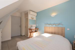 a bedroom with a white bed and a blue wall at Le Chalet des Retrouvailles in Sers