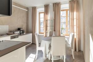 a kitchen and dining room with a table and chairs at Rennweg 114 BELAMI LIVING in Merano