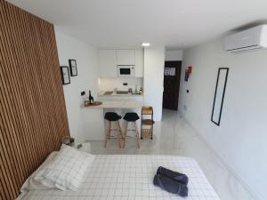 a white room with a bed and a kitchen at BlumLuxury Apartment in San Bartolomé