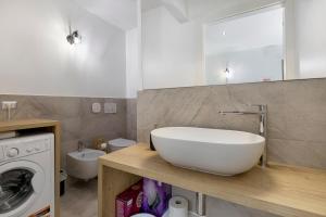 a bathroom with a sink and a washing machine at Lo Sarvanot in Bernezzo +53 photos