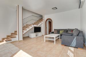 a living room with a couch and a tv and stairs at Casa Oasis in Tías