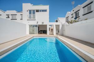 a villa with a swimming pool in front of a house at Casa Oasis in Tías
