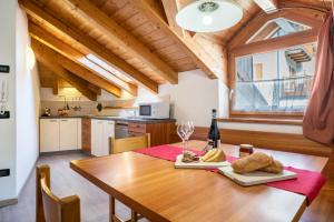 a kitchen and dining room with a wooden table at Casa Mirtillo Batistei in Molveno