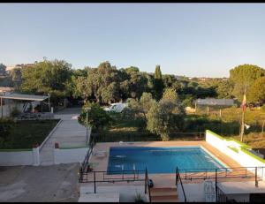 a large swimming pool in a yard next to a house at Villa verde Pet-friendly in Córdoba