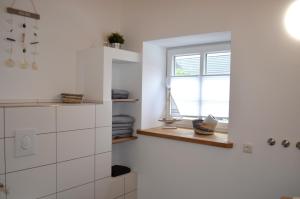 a white kitchen with a window and a window sill at Gut Bennewohld in Heide +89 photos
