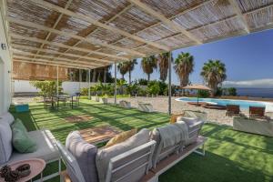 a patio with chairs and a table and a pool at La Casa del Caballo in Adeje