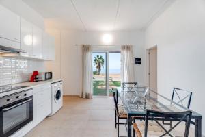 a kitchen with a table and a dining room with the ocean at La Casa del Caballo in Adeje