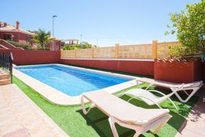a swimming pool with two lounge chairs next to a house at Casa Meli in Finestrat