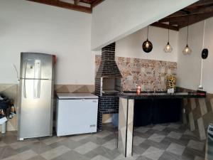 a kitchen with a refrigerator and a table in it at Cachoeira Paulista Espaço Cassicay in Cachoeira Paulista