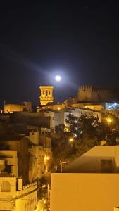 a view of a city at night with the moon at Apartamento Aljibe in Arcos de la Frontera