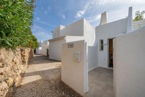 a building with white walls and a stone wall at Villa Valentina in Carvoeiro