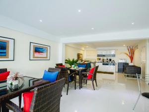 a living room with a table and chairs and a kitchen at Anchor Boutique House in Patong Beach