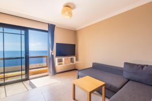 a living room with a couch and a view of the ocean at Costa Fortuna in Poris de Abona