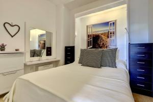 a bedroom with a white bed with two pillows on it at Marina de la Duquesa 805 in Manilva +15 photos