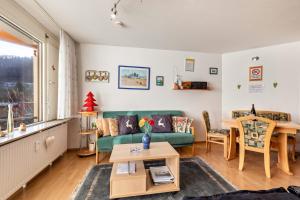 a living room with a green couch and a table at Studti 134 in Beuren