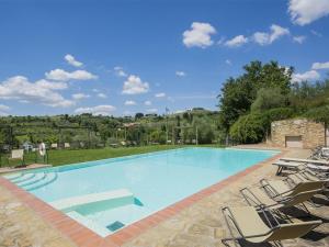 a large swimming pool with lounge chairs in a yard at Appartamento il Melo in Grassina