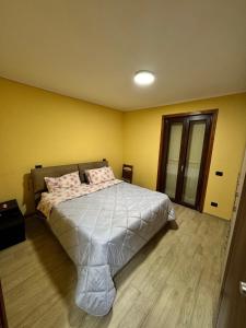 a bedroom with a bed and a yellow wall at Stef House in Rivisondoli