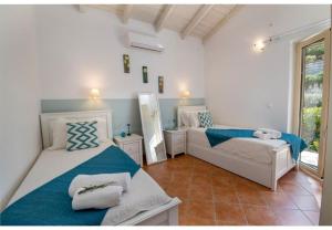 a bedroom with two beds and a mirror at Villa Aloni in Lákka +29 photos