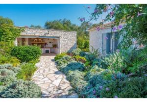 a garden with a stone walkway in front of a house at Villa Aloni in Lákka