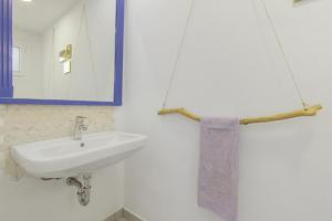 a bathroom with a sink and a mirror and a towel at La Casa de las Hesperides in Morro del Jable +19 photos