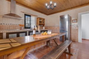 a kitchen with a large wooden table and a refrigerator at Villa Antonia in Betancuría
