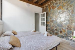 two beds in a room with a stone wall at Villa Antonia in Betancuría +23 photos