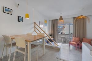 a dining room and living room with a table and chairs at La Casa de las Hesperides in Morro del Jable