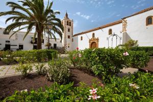 a church with a palm tree and a building at Villa Antonia in Betancuría