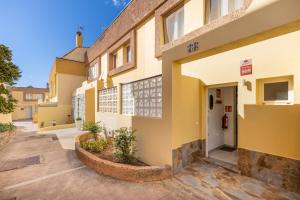 a building with yellow walls and a white door at La Casa de las Hesperides in Morro del Jable