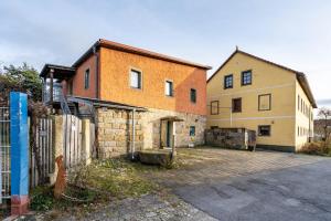 an old brick building with a fence next to it at Gemütliches Apartment In Lohmen in Lohmen