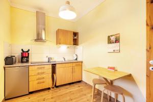 a kitchen with a wooden table and a table and chairs at Gemütliches Apartment In Lohmen in Lohmen