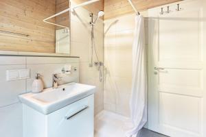a white bathroom with a sink and a shower at Sommerberg in Unterkirnach +23 photos