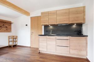 a kitchen with wooden cabinets in a room at Haus Mader 1 in Riscone