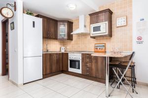 a kitchen with wooden cabinets and a white refrigerator at Apartamento el Carmen in El Cotillo +20 photos