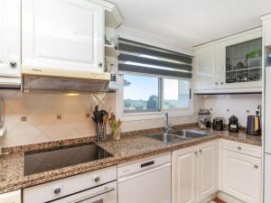 a kitchen with white cabinets and a sink and a window at Apartment Coco Golf by Interhome in Sant Jordi