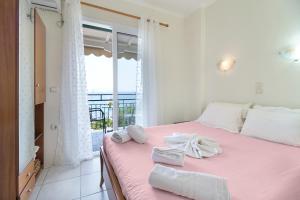 a bedroom with a pink bed with towels on it at S8 room in Nikiana